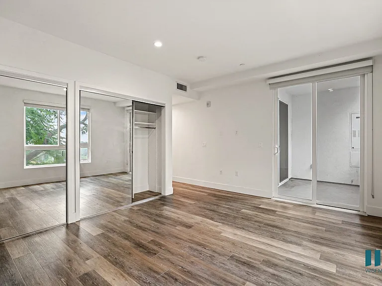 Bedroom with Mirrored Closets, Vinyl Flooring, and Patio