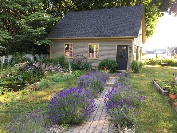 FROM THE BACK DEC : VIEW THE TWO CAR DETACHED GARAGE/ WATER FEATURE/ LAVENDER PLANTS AND RAISED BEDS