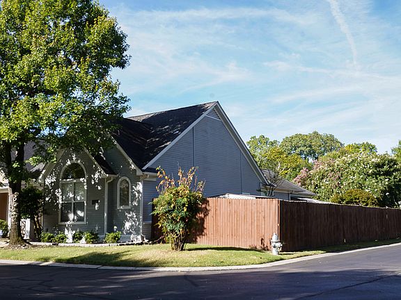 Front of house with picture of large fenced yard.