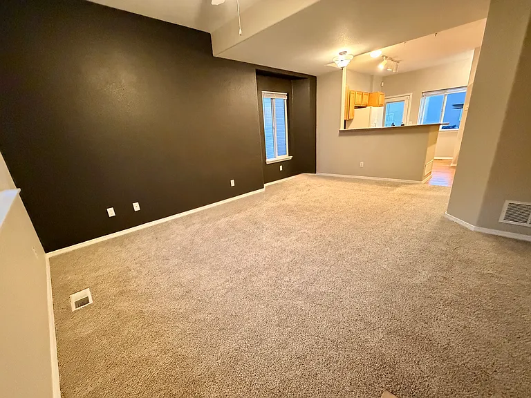 View of main level living room showing kitchen and angle from front door.