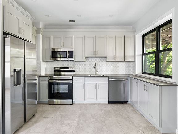 Kitchen featuring new quartz countertops, and brand new stainless steal appliances including dishwasher, oven, microwave and refrigerator.