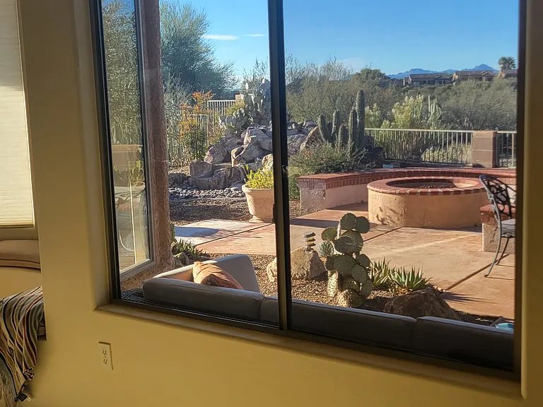 A window view (facing southeast) of water fountain, fire pit, patio. Large Outside seating is just below window.