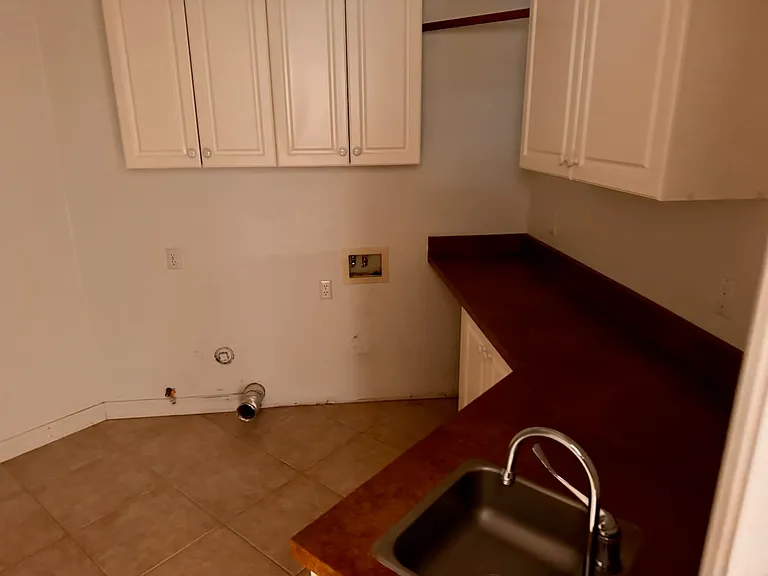 Laundry room w/sink, folding counter, shelves and electric hookup for washer and gas hook up for dryer