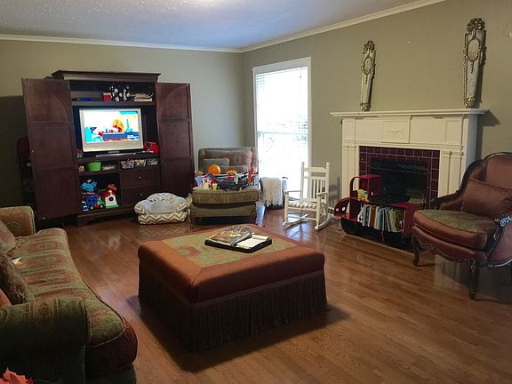 Full living room with fireplace connected to covered front p