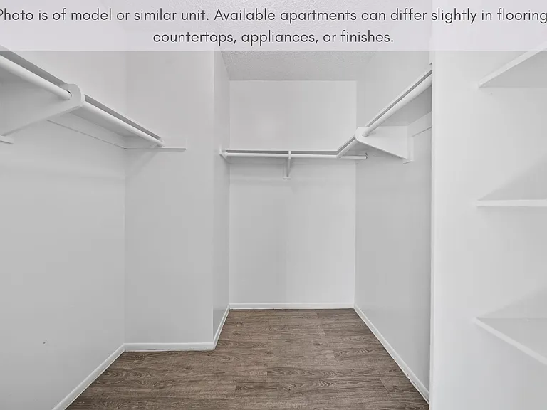 Spacious walk-in closet with built-in shelving and ample storage space.