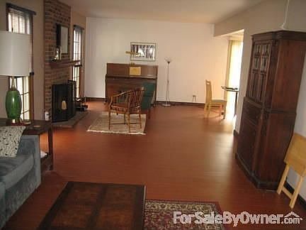 Living/Family Room, back of house : Wood burning fireplace on left and continues into kitchen on the