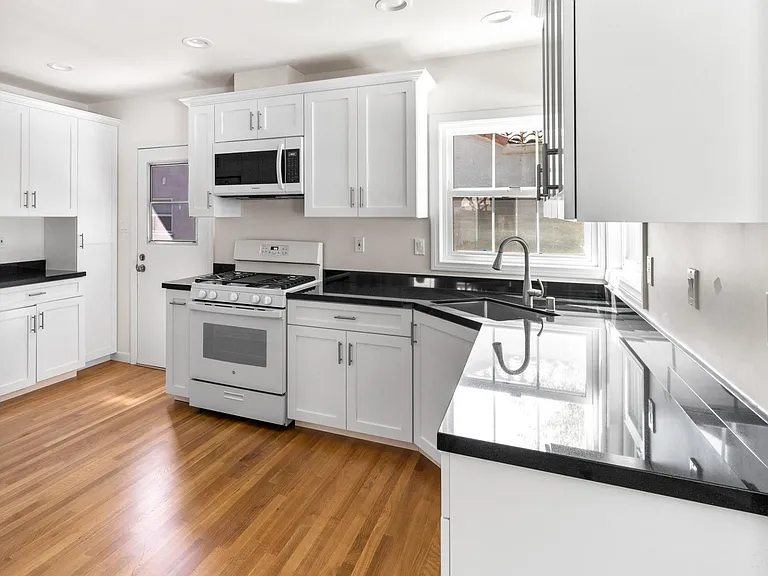 Brand new kitchen with new French door refrigerator, new range, new dishwasher, new microwave, new garbage disposal and new cabinets and granite counter tops