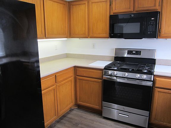 Both griddle-top range and microwave have never seen use. side-by-side fridge on the left is less than 2 years old, New cutting boards also serve to protect countertop surface from hot cookware. Counter top is lighted.