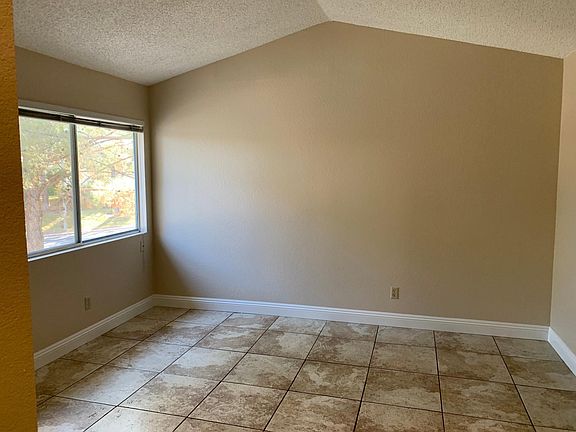 Master Bedroom with vaulted ceiling with window open to luscious pine trees.