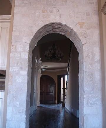 Dramatic Austin stone archway from Foyer into Family Room