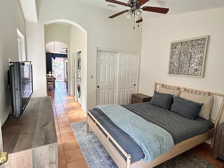 Bedroom with queen bed, closet, dresser, nightstands, shelf, small TV, high ceilings