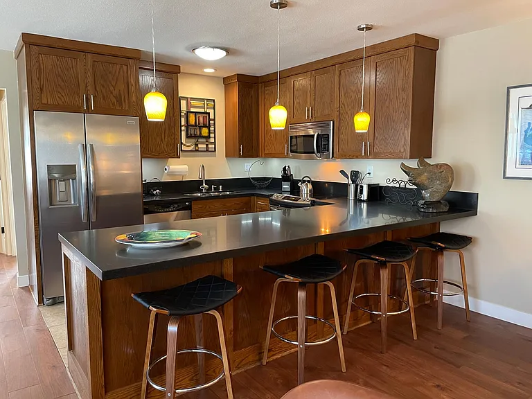 The kitchen has granite counters and has bar seating for four