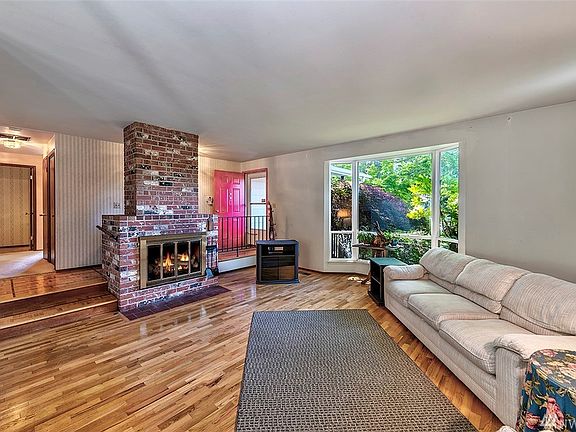 Living room with a gas brick fire place and high ceilings.