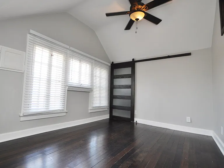 Large bedroom with vaulted ceiling, walk-in closet with chic barn door closure, Ceiling fan, and real Douglas fir hardwood floors