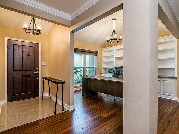 Beautiful solid wood front door with little window to see who is out there.