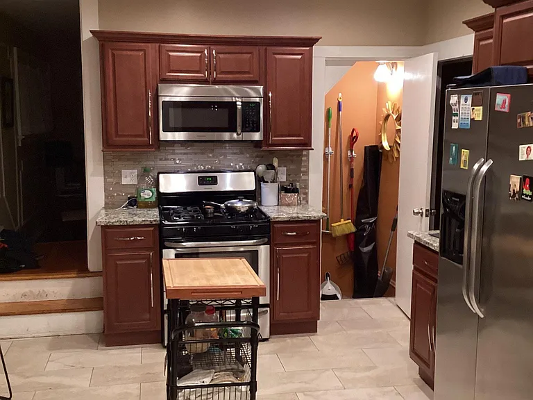 This is the reverse view of the kitchen (the basement door is open to show the broom/mop)
