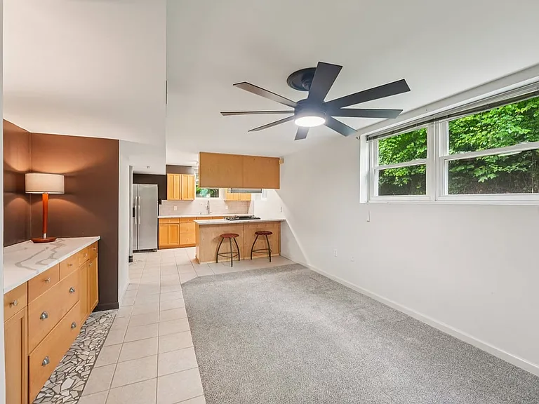 With its airy feel, private kitchenette, modern ceiling fan, and garden views, this lower level space feels like a sweet little hideaway within the home.