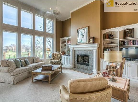 Sunny great room with a wall of windows overlooking the golf cou