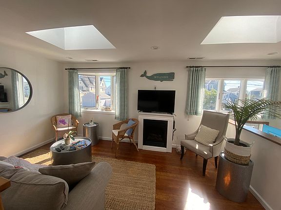 cozy living room, water views across the way, beach access, plenty of natural sunlight