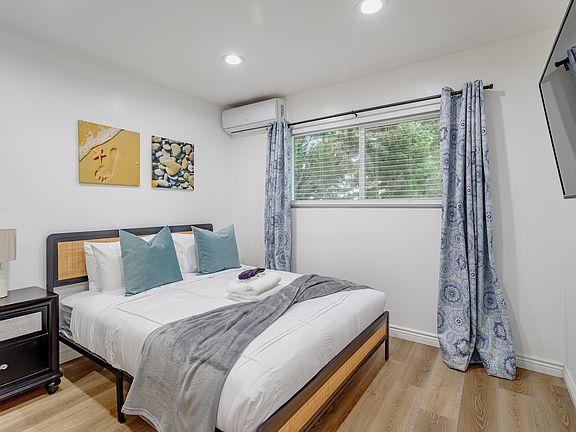 Second bedroom of the home with a queen bed and Roku Smart TV.