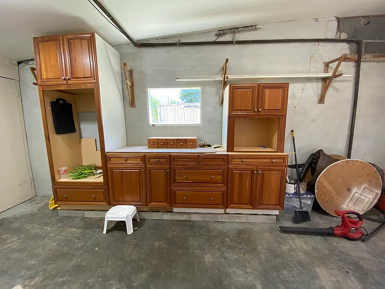 Garage inside: The extra cabinets, too nice for the garage, are placed here to have easy access to tools used for projects. East window and large lights keep the garage well lit. PS - extra items will be removed __