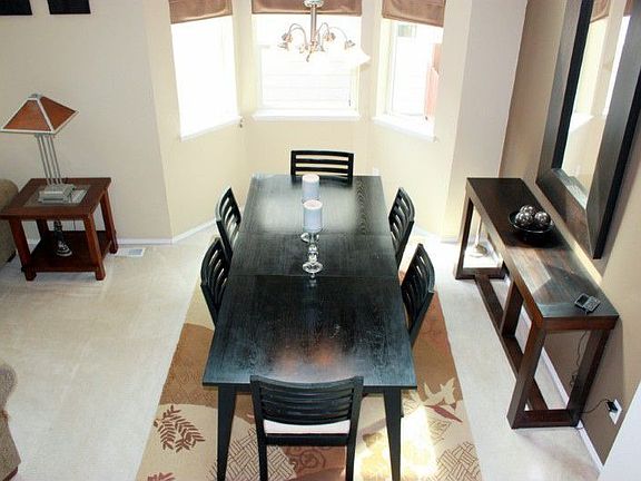 An all occasion dining room with a two story ceilings a bay window.