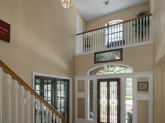 This home boasts an entryway that is light and bright! Natural light flows from the arched window above the leaded glass door, sidelights and balcony above! There is also a door to access the balcony creating a cozy reading book!