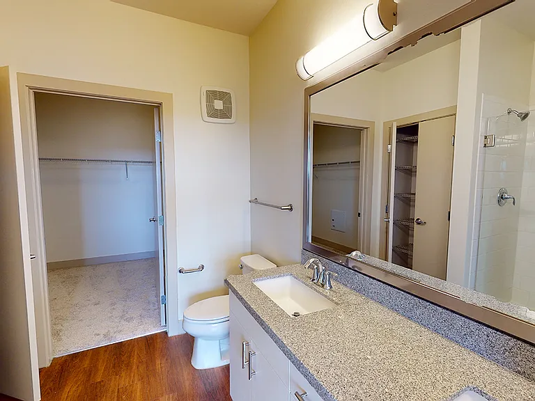 Apartment bathroom with wood-style flooring.