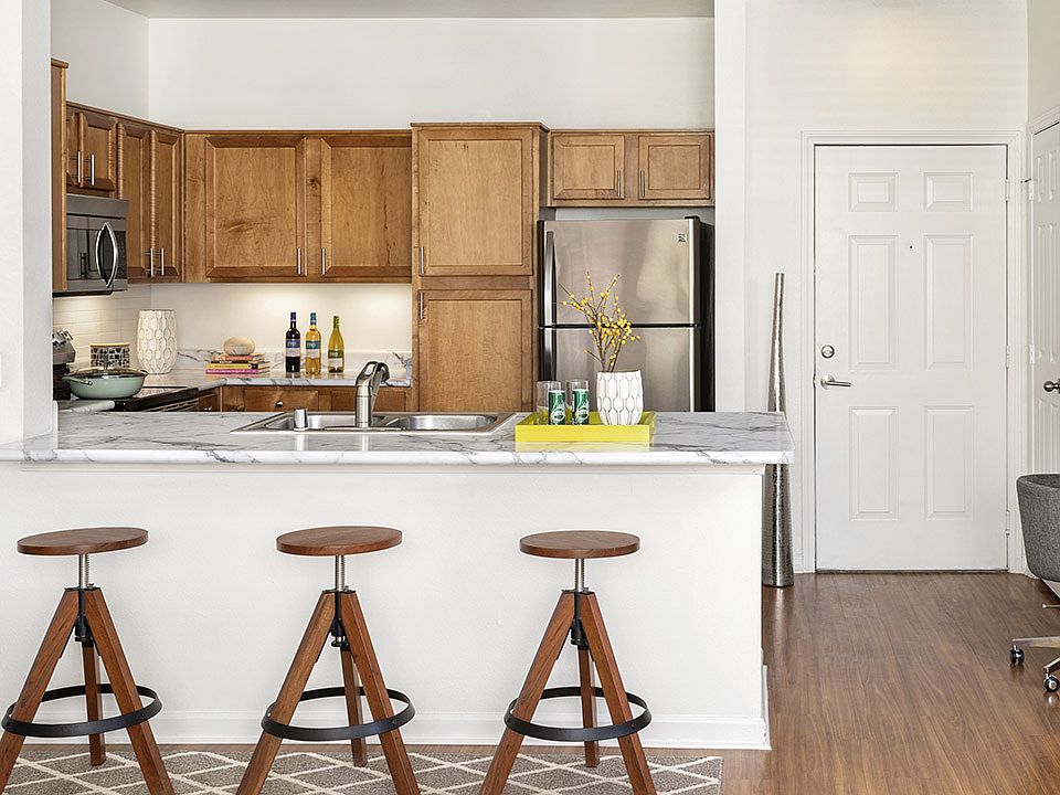 Apartment Kitchen with Stainless Steel Appliances, quartz counters and wood floors.