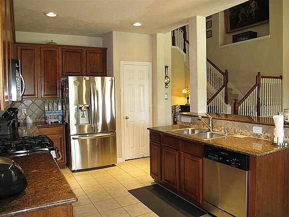 The open kitchen has 42" cabinetry, recessed lighting, large breakfast bar, and spacious pantry!