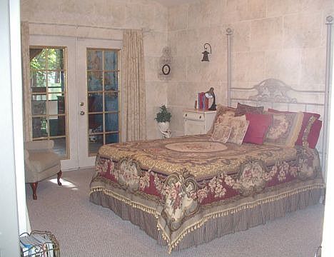 Master bedroom has a high ceiling and opens onto back party porch.