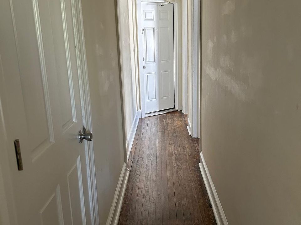 Long central and main hallway separating the large front room from the middle bedroom, the kitchen, and the back room.