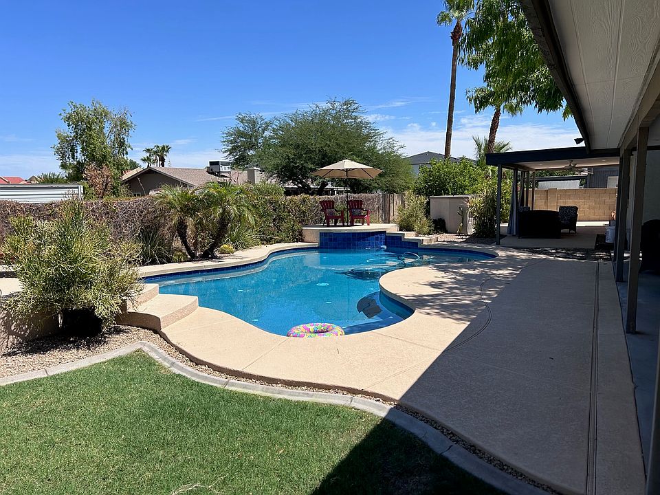 Backyard with built in barbeque, lounge chairs and seating areas.
