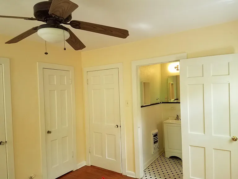 Bedroom, two closet doors on left, door to living rm (middle), bathroom