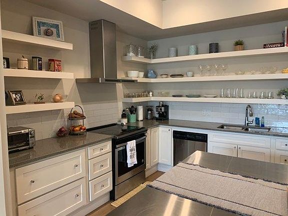 Kitchen with open shelves, dish washer, stove/oven, refrigerator and pantry