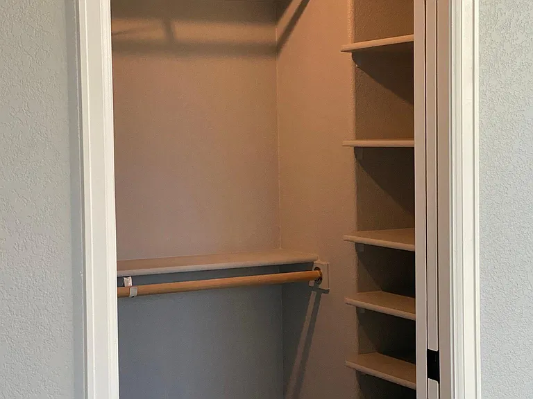 Custom shelving in the bedroom closet provides room and easy access. Hanging rods for everyday and office wear as well as an area for evening wear provided.
