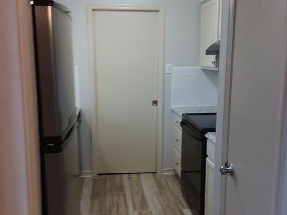 Galley style kitchen pantyry to utility room with washer and dryer hookups.