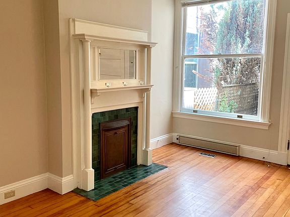 Light filled bedroom and decorative fireplace.