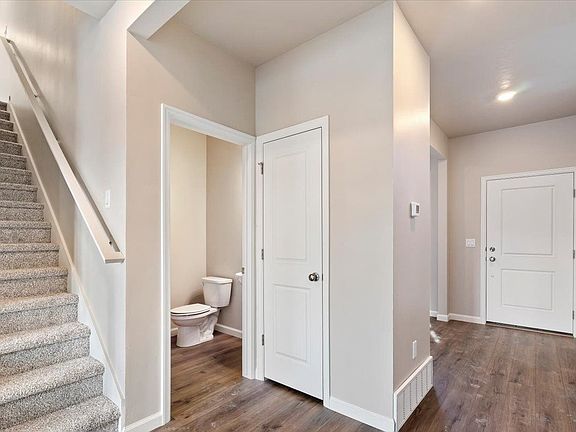 A view of the stairwell, entry and powder room
