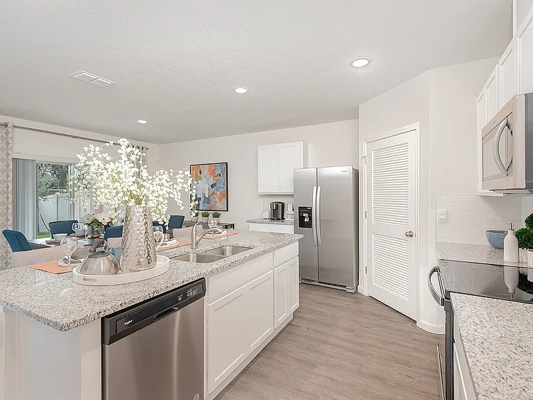 Bright and modern kitchen with sleek granite countertops, stainless steel appliances, and an elegant dining area in a stylish open-concept layout.