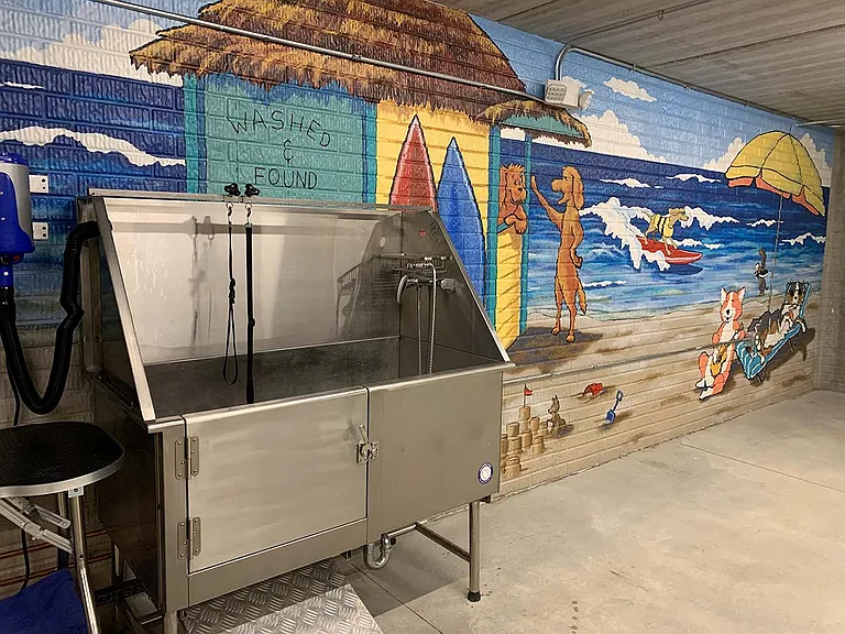 Our pet spa offers a fun and functional space to pamper your furry friends, complete with a vibrant mural and professional-grade washing station.