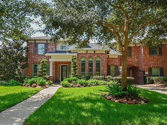 Huge front yard with privacy gate to 3 car garages.