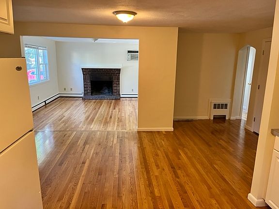 View from kitchen into living room and hallway that leads to bedrooms and bathroom.