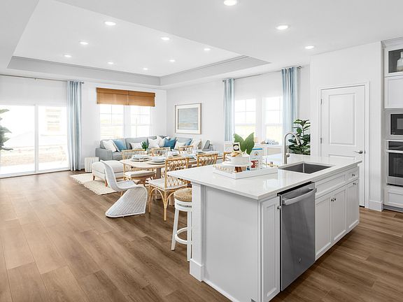 Kitchen overlooking the great room with luxurious wood flooring