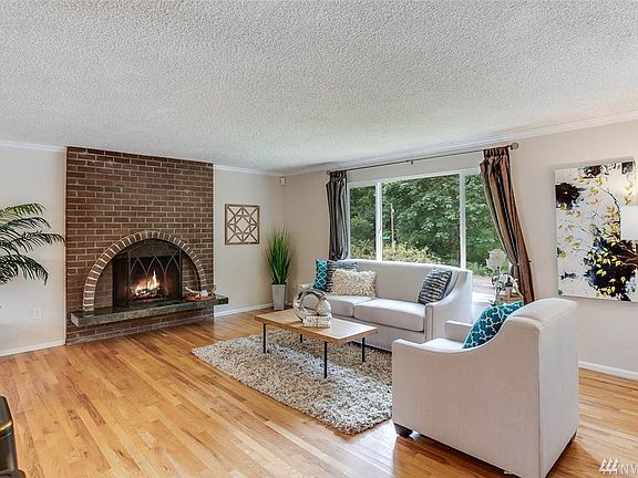 Light filled living room with its natural wood fireplace welcomes you.