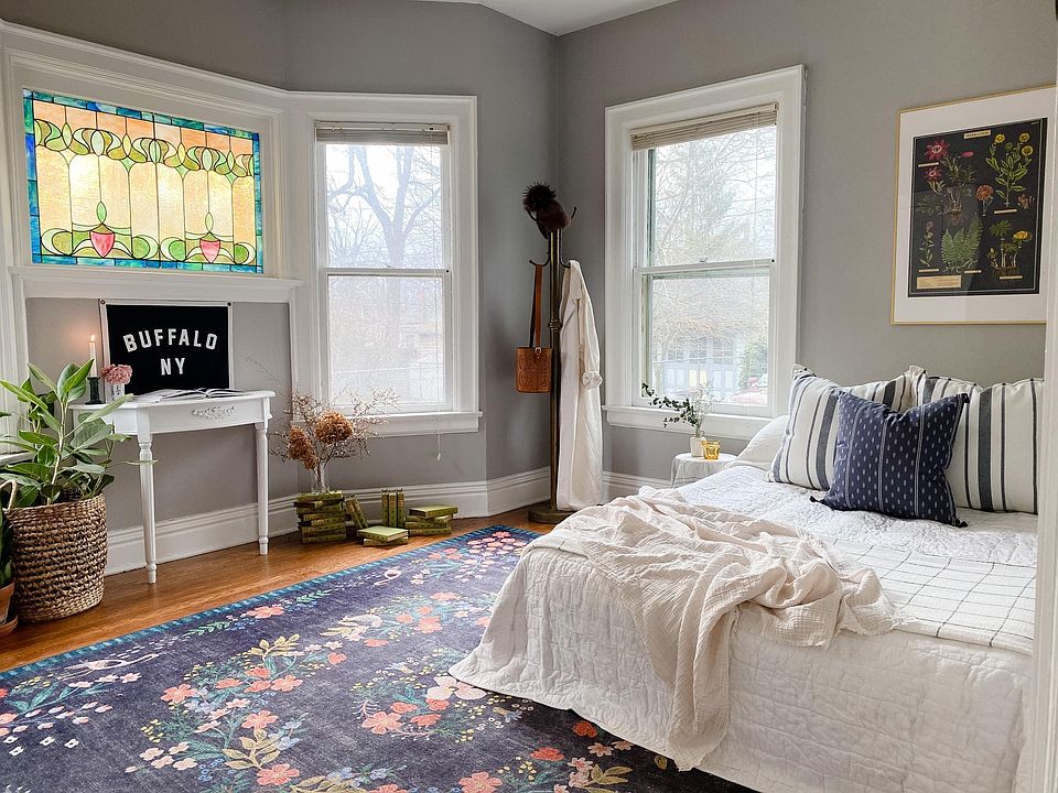 Spacious bedroom with great hardwoods, tall ceilings and plenty of bright light, featuring a beautiful leaded stained glass window