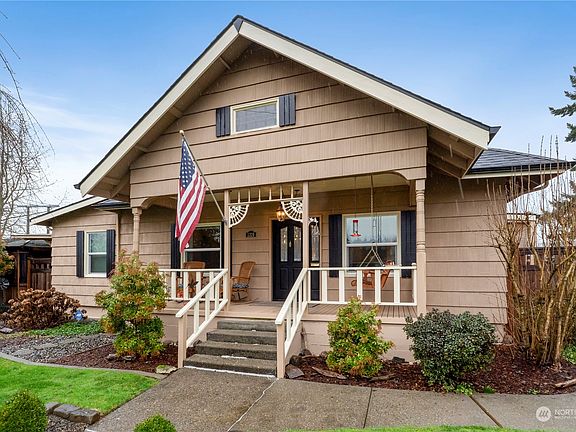 Relax on your covered porch year round with your favorite beverage while resting on the porch swing>