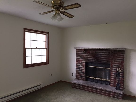 Living room with fireplace and fan