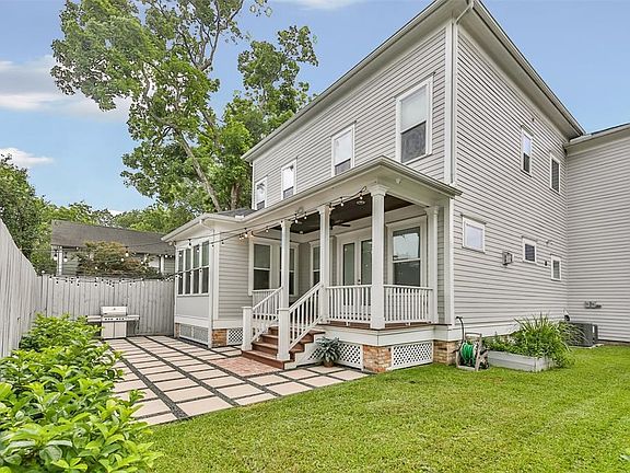 Spacious backyard offers covered porch and pavers.