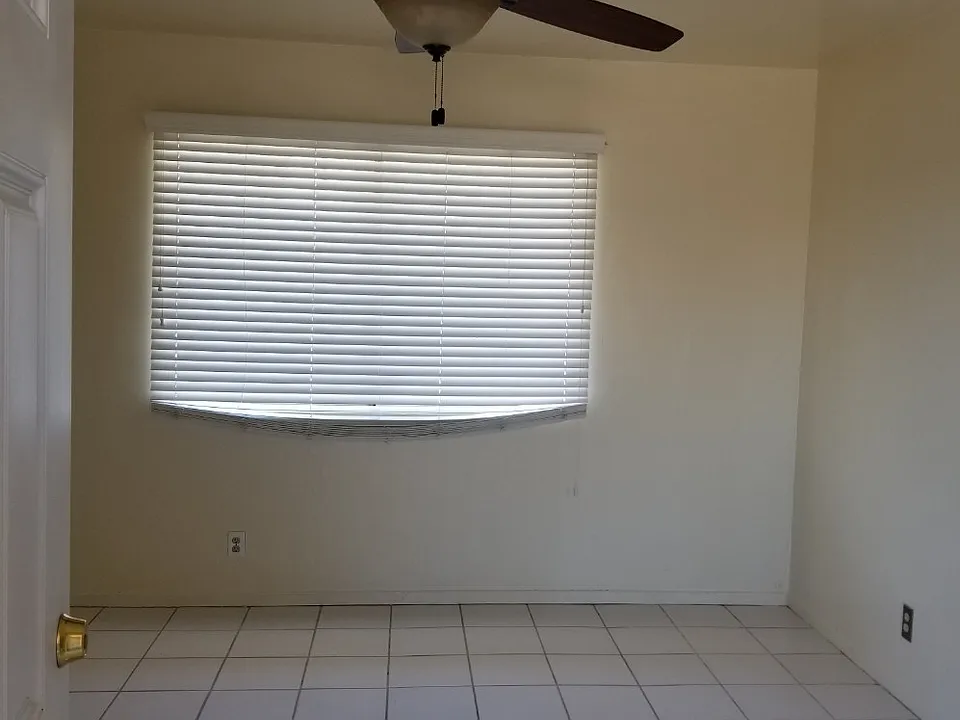Living room with 52 inch ceiling fan and faux wood blinds